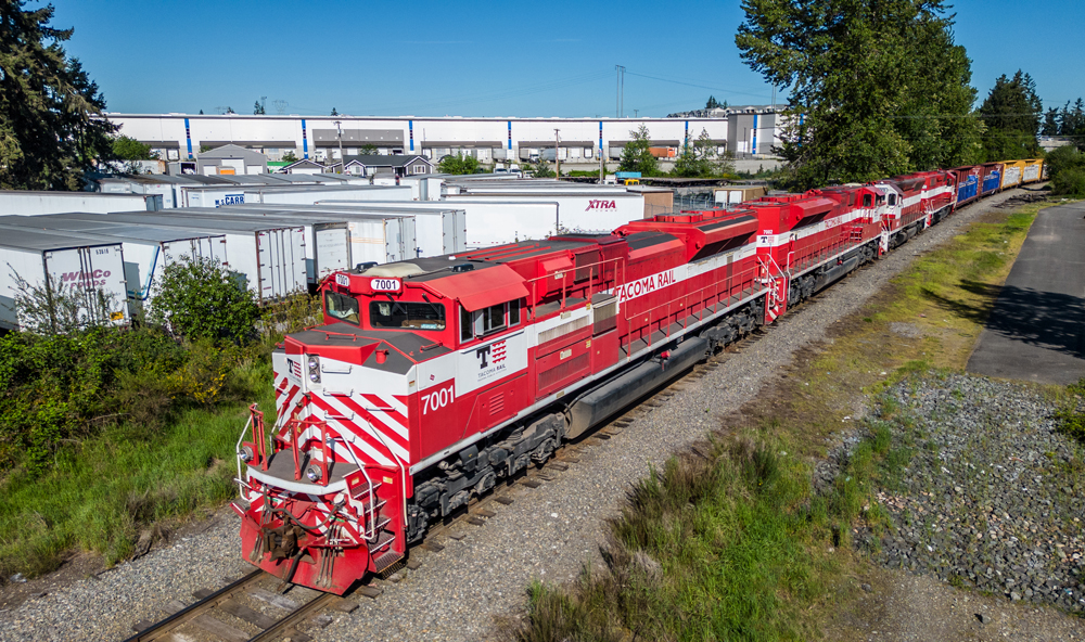 Red and white diesel locomotive pulling train.