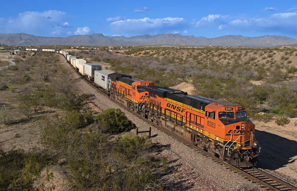orange BNSF train surrounded by desert