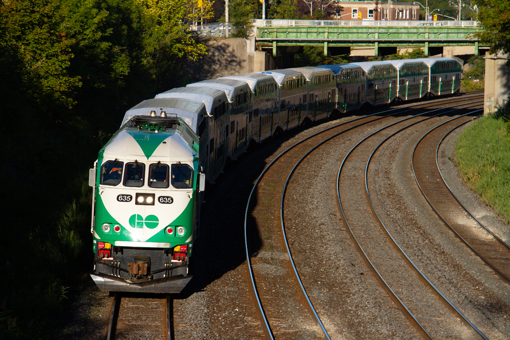 green and white train going around curve