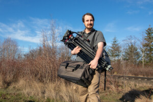 Videographer holding tripod.