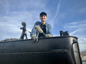 Videographer on top of tender with camera.