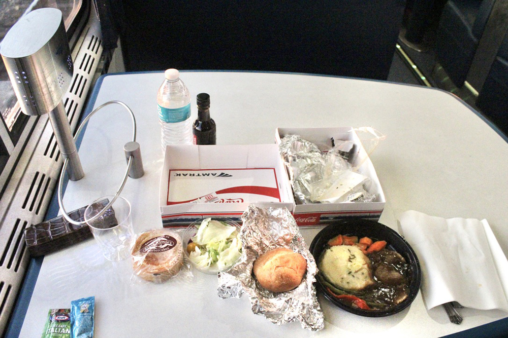Food and packaging on table in dining car.