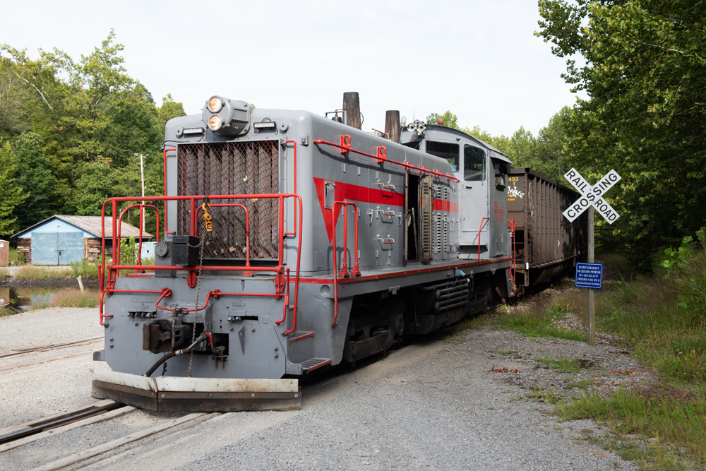 Silver and red switcher with hopper cars