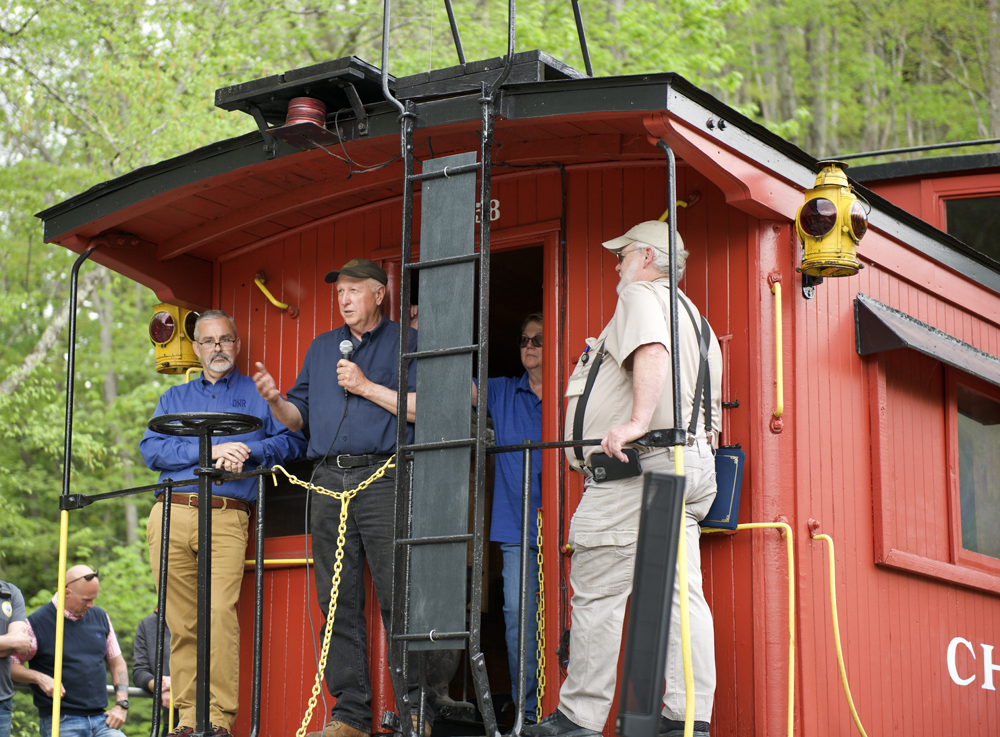 Man speaking from rear platform of caboose