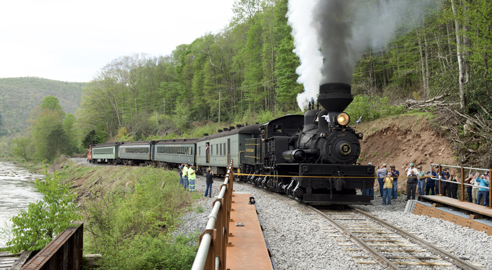 Steam locomotive and train at bridge
