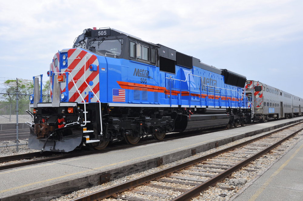 Blue six-axle locomotive with red-and-white striped nose