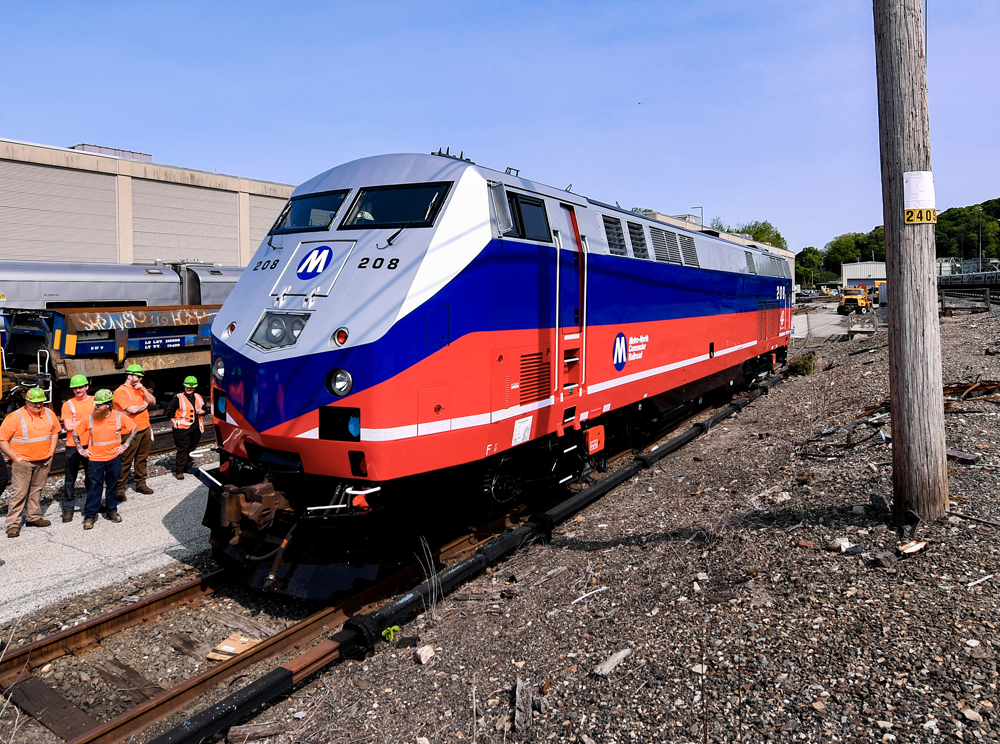Red, blue, and silver diesel locomotive in yard