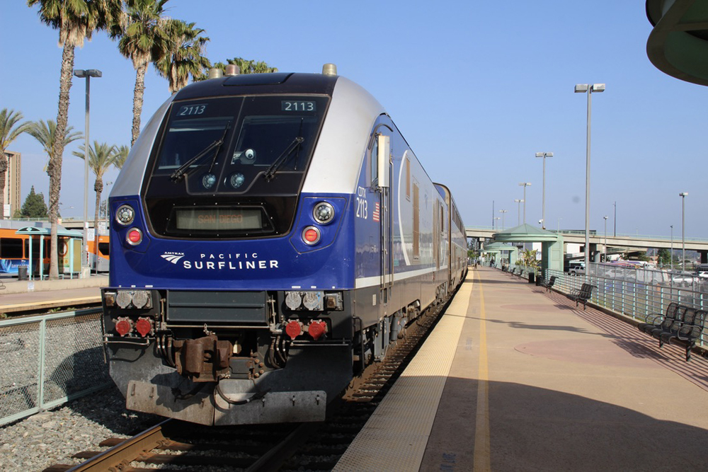 Locomotive pushing passenger train stops at station