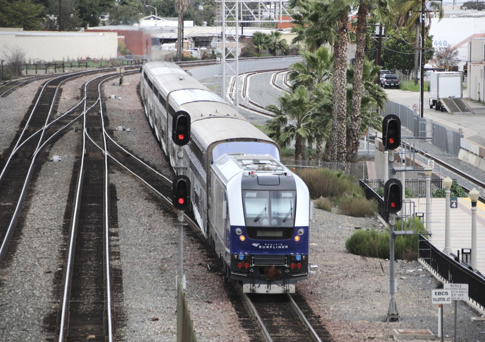 Passenger train departs station, as seen from bridge