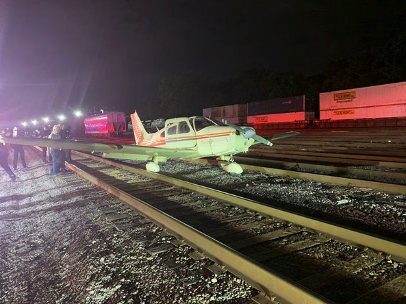 Airplane on railroad tracks in yard