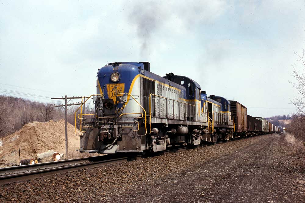 Blue-and-gray diesel locomotives with freight train of Delaware & Hudson history