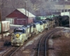Silver-and-blue diesel Delaware & Hudson locomotives with freight train in town