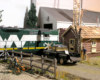 green and white diesel locomotive near grain elevator on garden railway