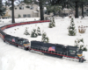 black model diesel with long train on curve and a snowy scene on garden railway