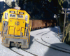 model yellow diesel engine heading toward camera on curve