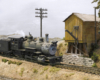 A steam engine trailed by a caboose pulls to a stop at a square wooden water tank