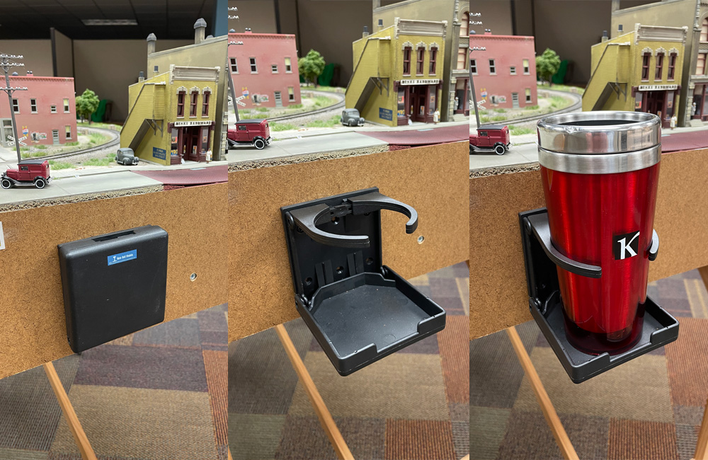 Three images show a black plastic drink holder on a layout’s fascia folded flat, opened, and holding a drink