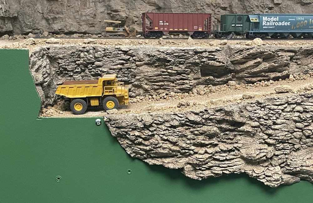 A dirt road descends through rocky scenery that extends down into the fascia