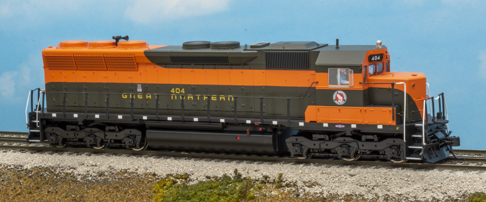 Color photo of HO scale six-axle locomotive painted orange and green.