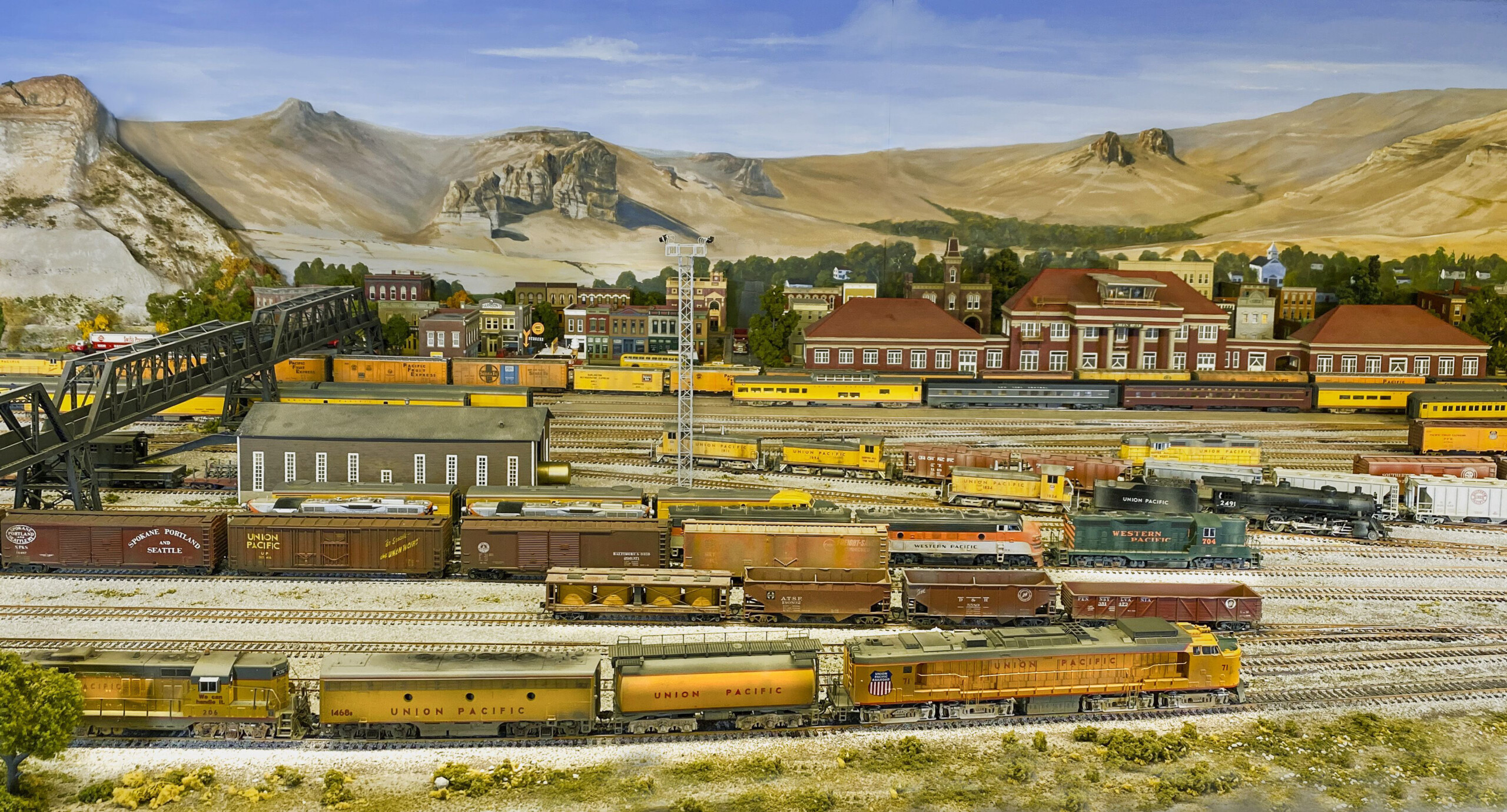 The Green River layout in HO scale: An image of a model railroad layout, with trains in the foreground and structures in the background