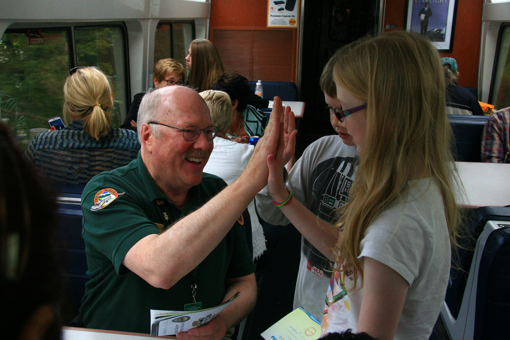 kid high-fiving man on train