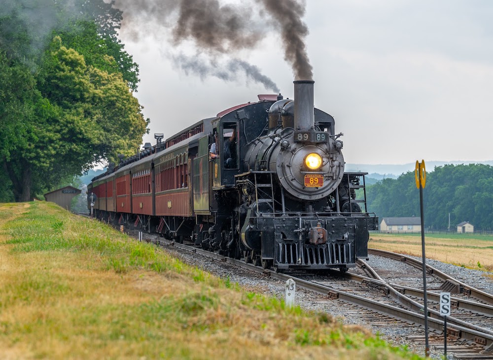Steam-powered passenger train with wooden coaches
