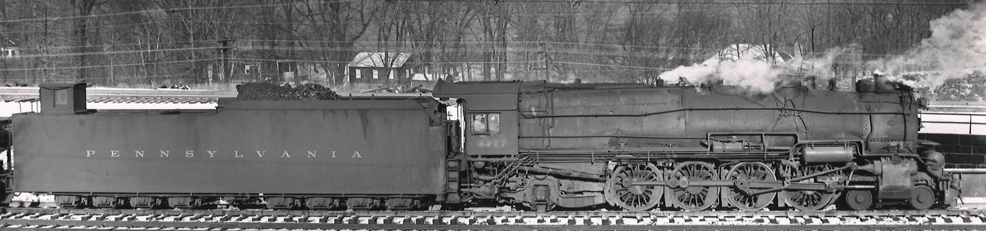 Steam locomotive with dog house on back of tender.