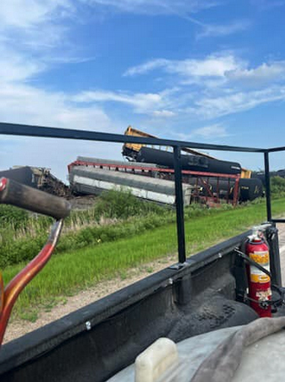 View looking from back of truck at derailed railroad cars