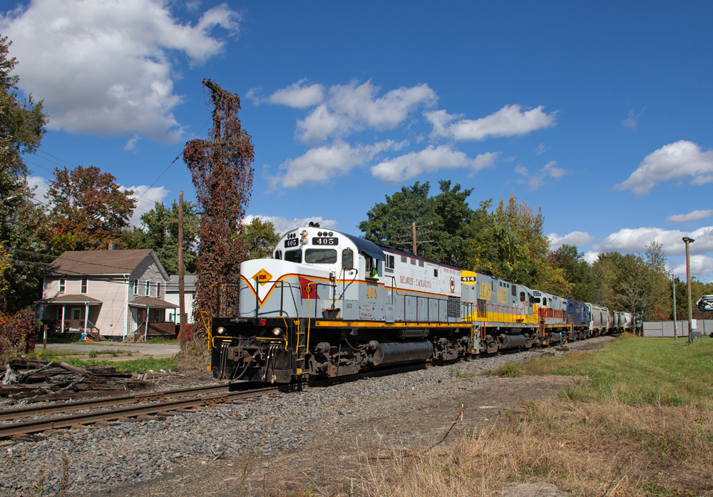 Four Alco locomotives lead freight train under blue skies