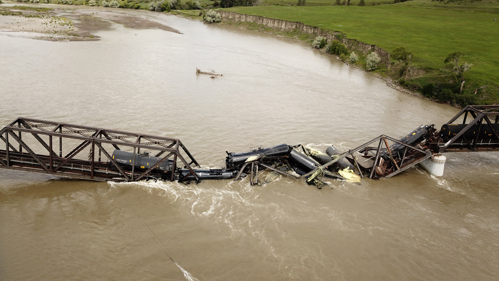 Aerial view of collapsed bridge and railcars in river