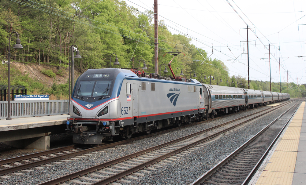 Electric locomotive and train arrive at station