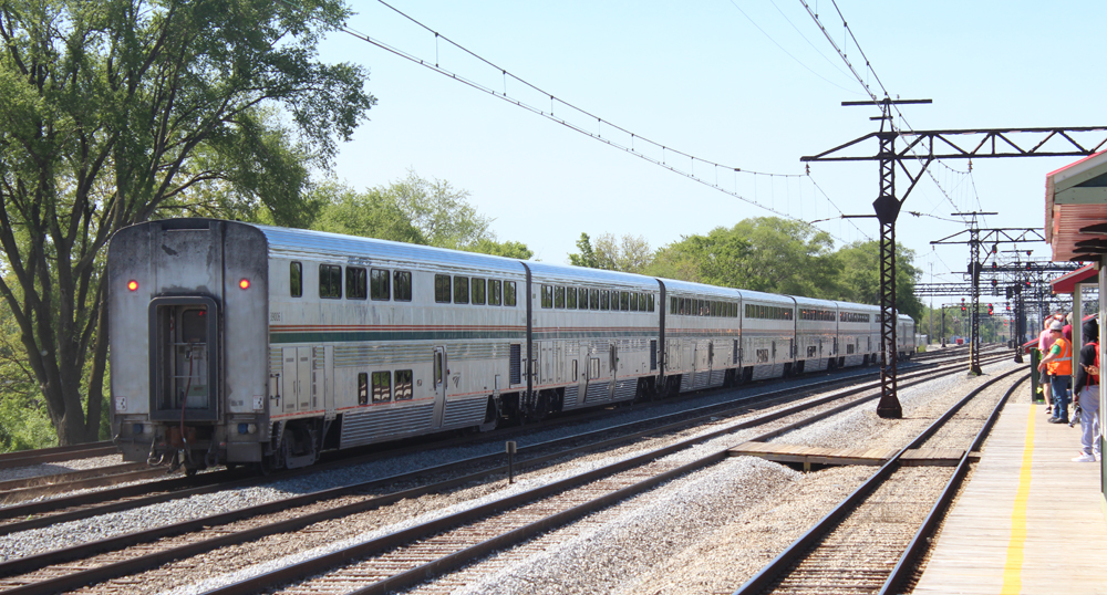 Seven-car passenger train with bilevel equipment passes station
