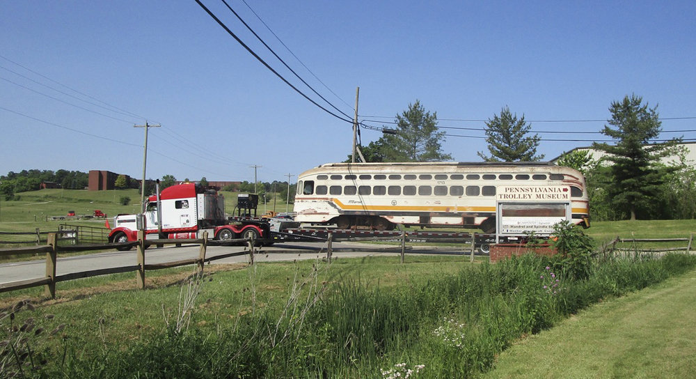 White PCC car on truck passes Pennsylvania Trolley Museum sign
