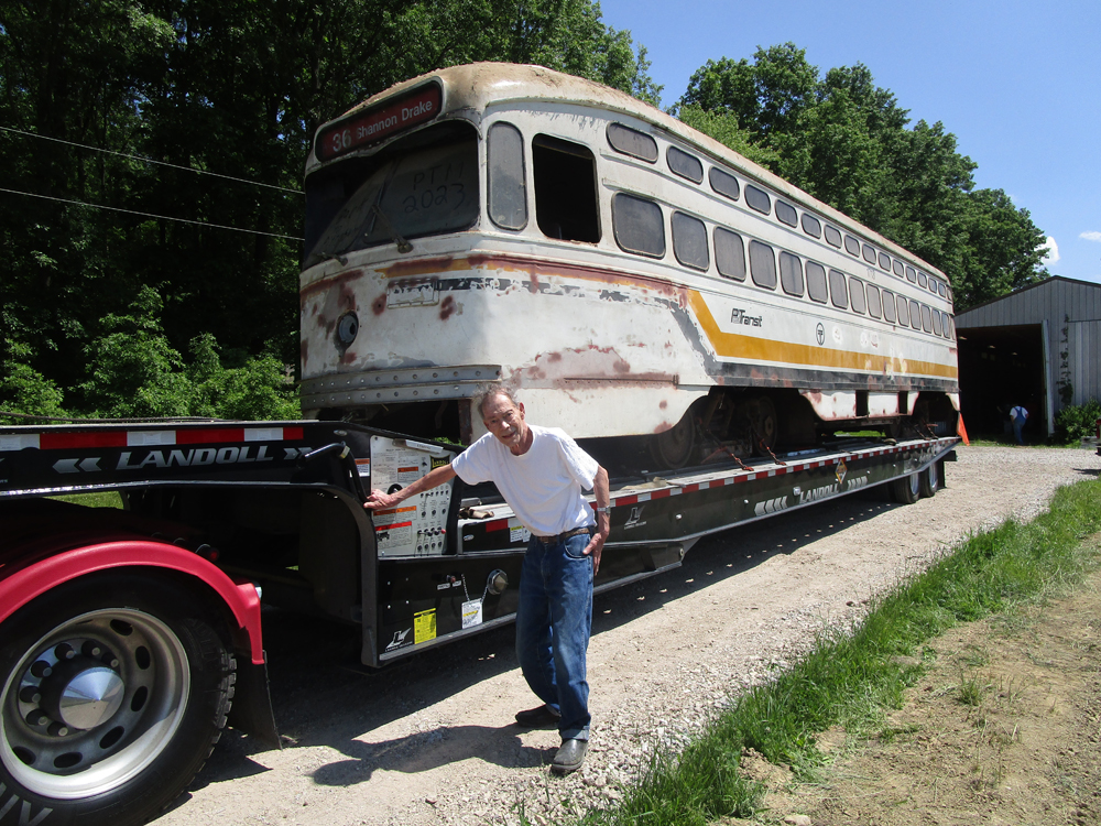 Man standing next to PCC car on trailer