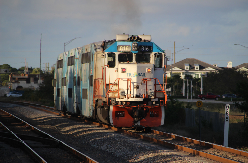 White and blue locomotive pushing commuter train