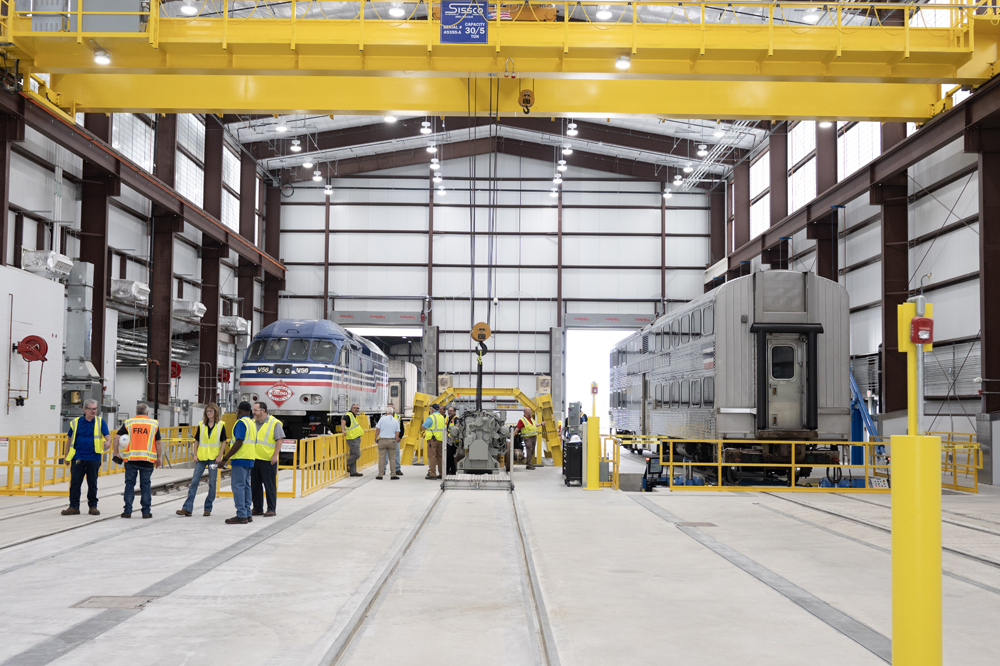 Interior of new shop building with locomotive and bilevel passenger car
