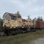 Yellow end-cab switcher with some body rust