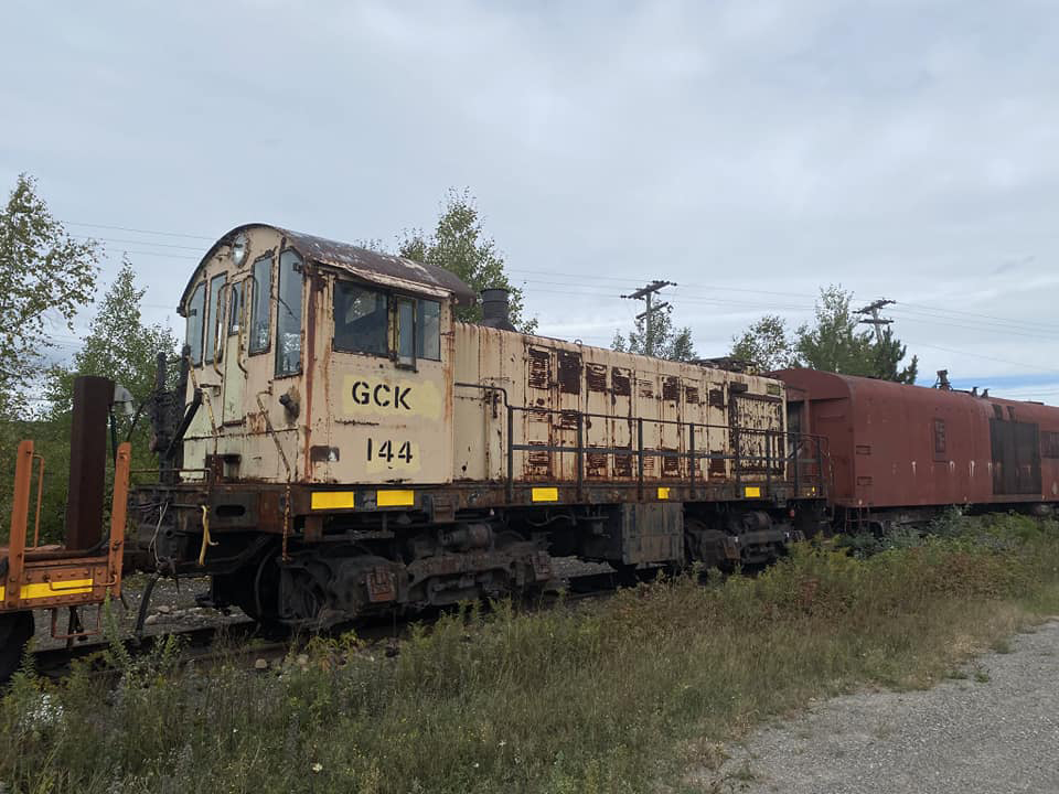 Yellow end-cab switcher with some body rust