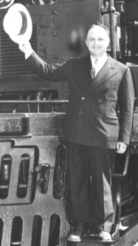 Man waving hat standing on front of Union Pacific Big Boy locomotive