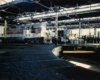 Gray-and-maroon diesel Algoma Central locomotives inside shop
