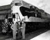 Men stand in front of diesel Algoma Central locomotives
