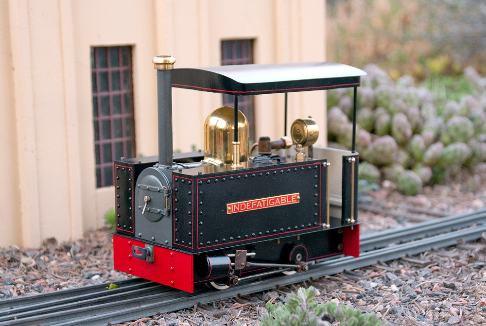 black and red model live steam engine on track