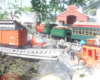 scene on garden railway with wagon, car, and station