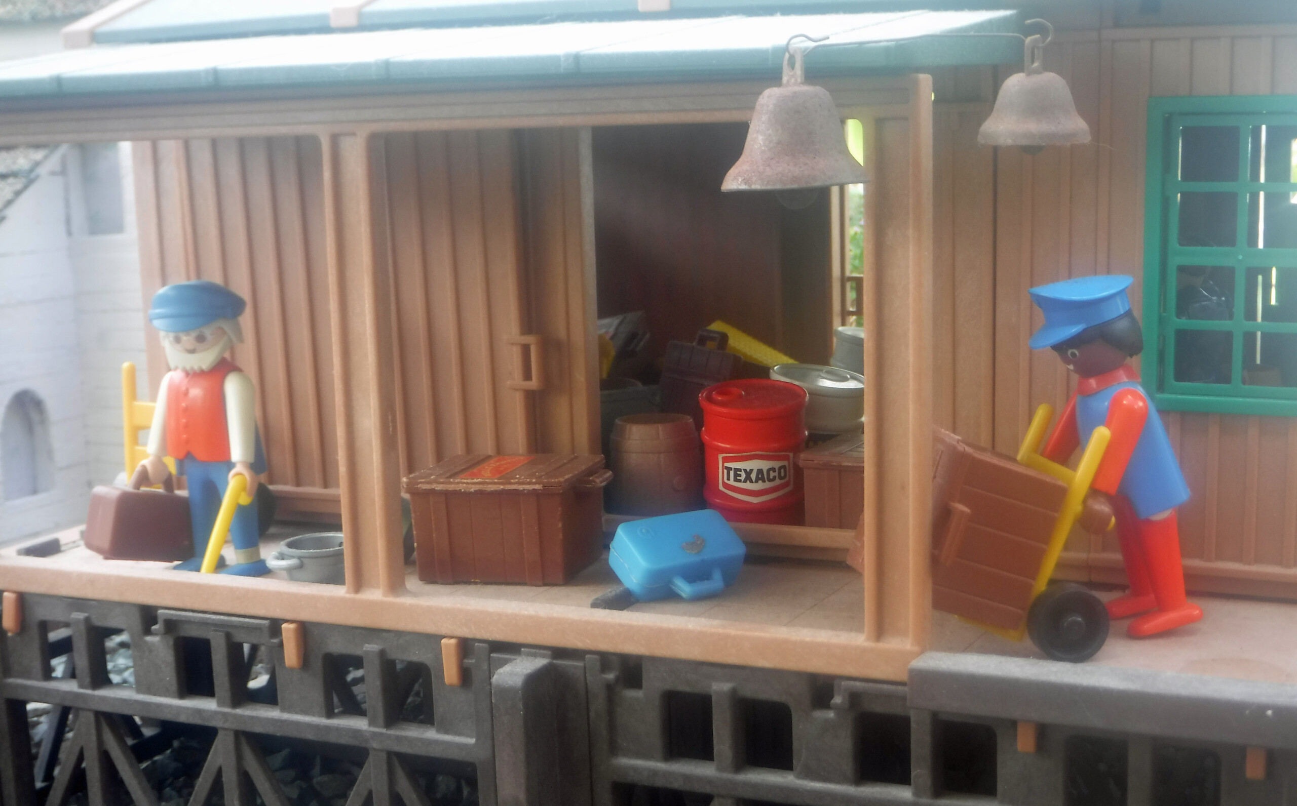 two figures hauling luggage in front of a freight house