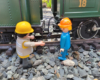 two figures next to a locomotive and tender