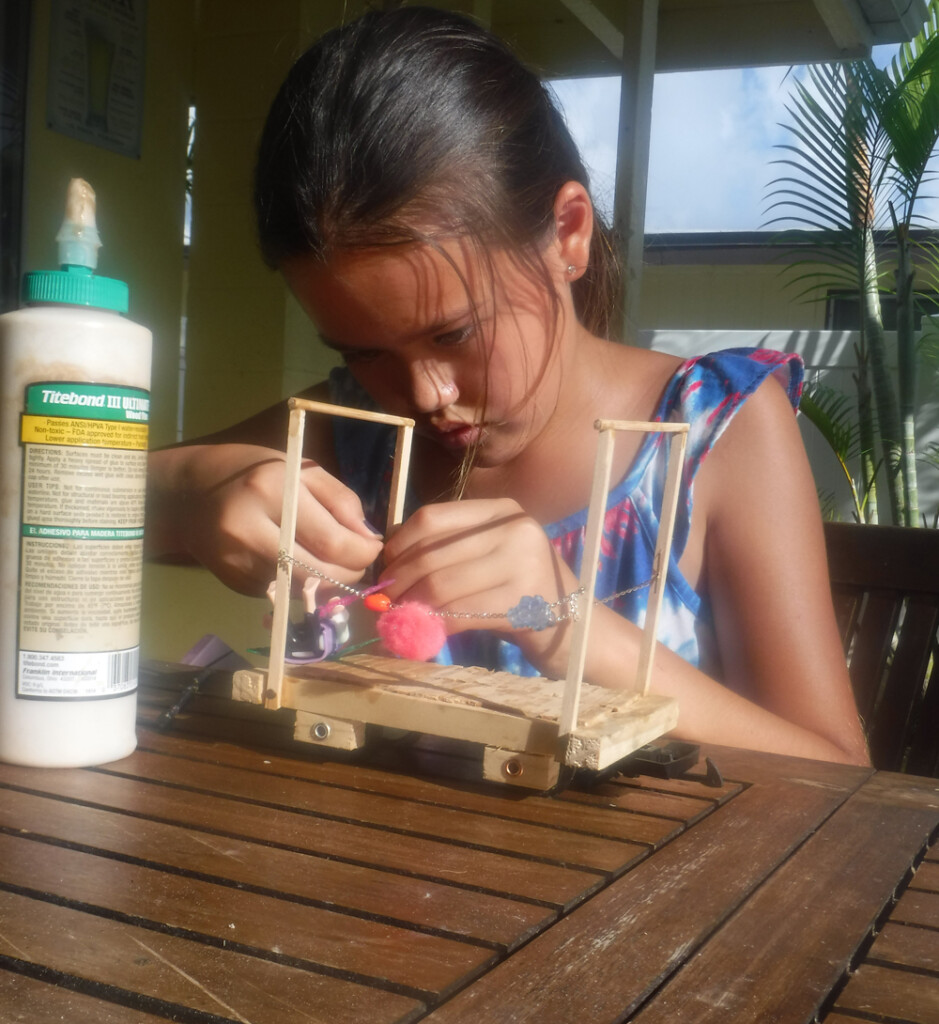 girl concentrating on building piece of rolling stock