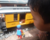 child peers inside yellow piece of model rolling stock