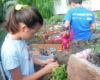 girl with pink toy dragon near garden railway