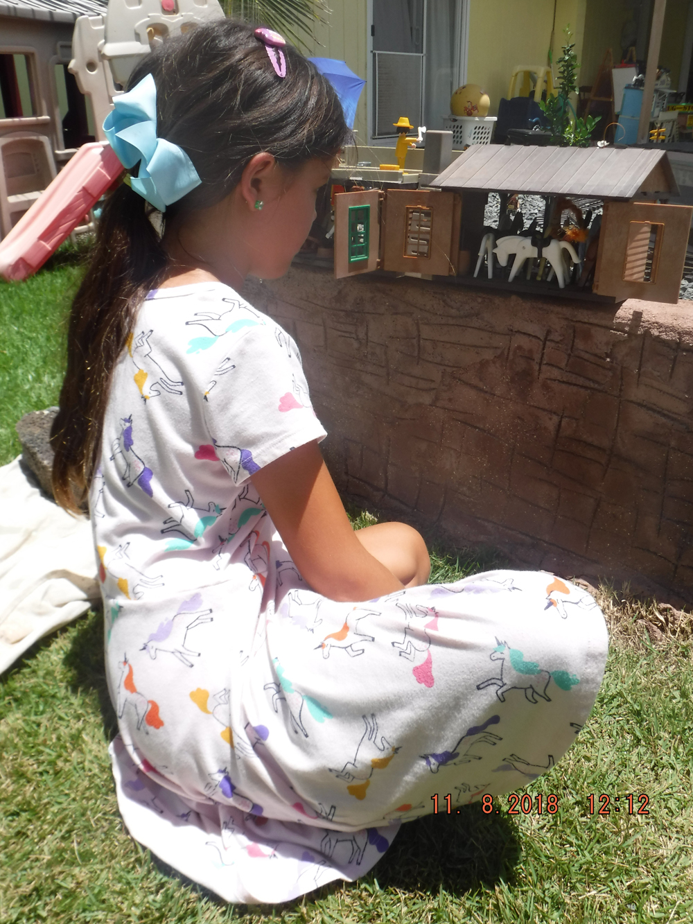 girl in dress next to model horse barn