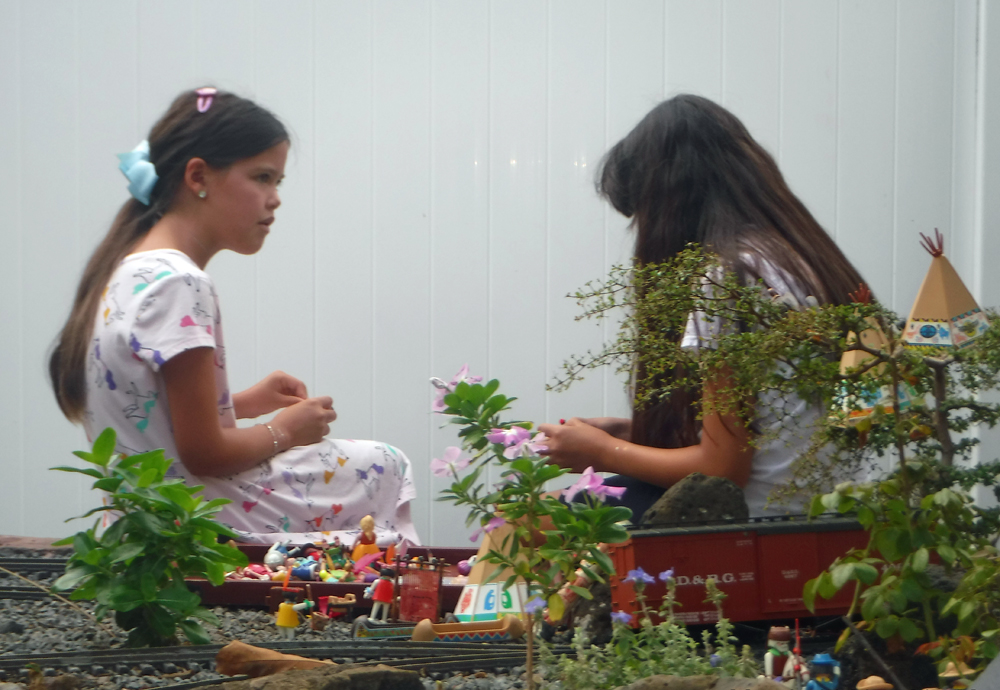 two girls sitting in garden railway